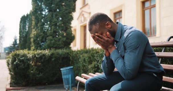 Triest en depressief jonge zwarte Afrikaanse zakenman zit moe na de oproep op de straat. Concept van slecht nieuws, teleurstelling, ziekte — Stockvideo