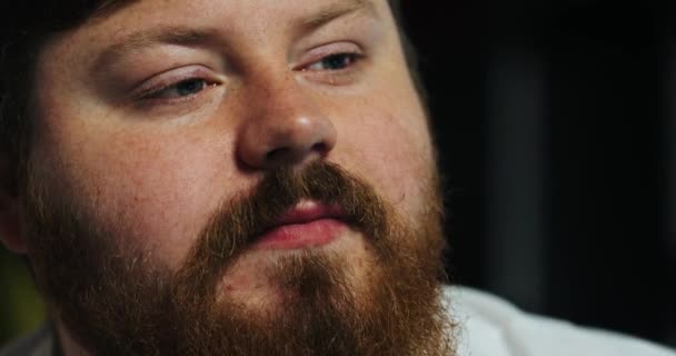 Primer plano de una cara de hombre gordo comiendo mirando el televisor, primer plano — Vídeos de Stock