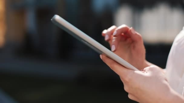 Close up de uma mulher e suas mãos usando um tablet na rua durante o dia — Vídeo de Stock