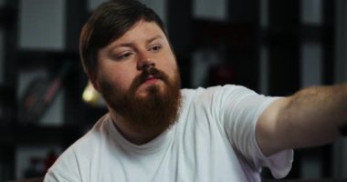 Şişman adam Tv ve türleri bir şey onun smartphone içinde izliyor. Eve yemek siparişleri. Yetersiz beslenme, gıda dağıtım, geri kalan kavramı