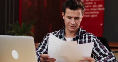 Mutlu genç iş adamı evrak masa ofis okuma. Casual adam gülümseyen. Belgeler çalışan adam. Sözleşme, başarılı iş kavramı