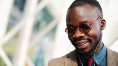 Video-çağrı street yürüyüş Afrikalı-Amerikalı adam görüşmelerde. İş, insanlar, müzik, teknoloji, eğlence ve yaşam tarzı kavramı