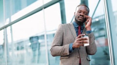 ciddi siyah iş adamı sokakta telefonla konuşuyor. O iş merkezi yanındaki - açık duruyor