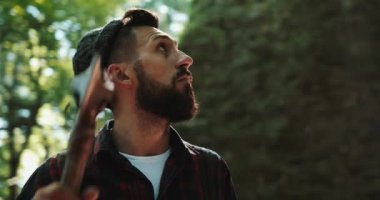 Baltasını ormanda ayakta, etrafa oduncu. Balta ile yakışıklı sakallı adam portresi