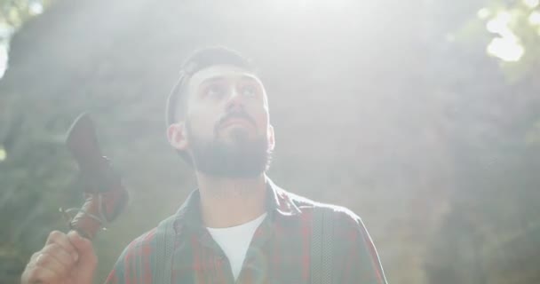 Bûcheron debout avec sa hache dans les bois, regardant autour. Portrait de bel homme barbu avec hache — Video