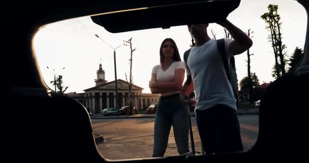 Pareja feliz enamorada saliendo de vacaciones cargando equipaje en el coche. Concepto de vacaciones, hora de verano. Concepto de vacaciones, mudanza, viaje en coche familiar — Vídeo de stock