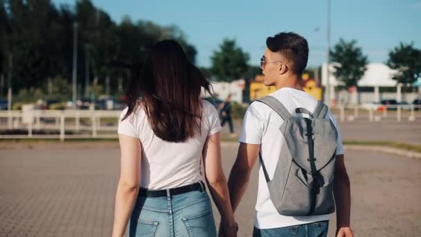 Felice giovane coppia va con i bagagli vicino all'aeroporto o alla stazione ferroviaria. Il concetto di viaggio, vacanze, vacanze. Ora esatta, tramonto — Video Stock