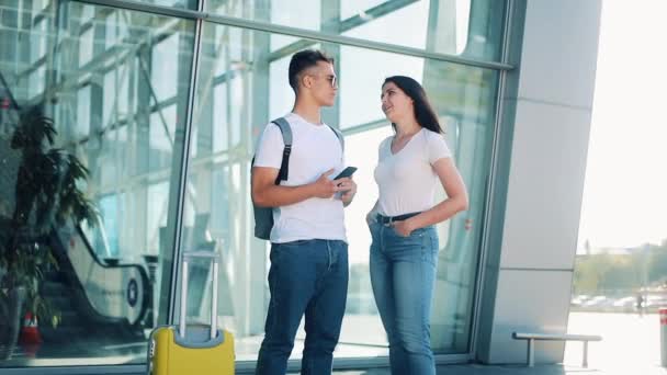 Beautiful couple in love standing near airport terminal, talking with each other. Business, contract, having a deal. Rest, travel, communication, transportation. Successful lifestyle — Stock Video