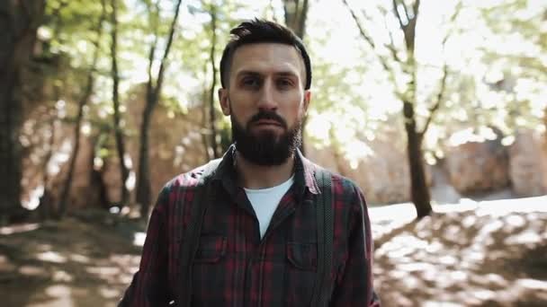 Ormanda yürüyüş yakışıklı sakallı adam portresi. Kameraya bakarak bir oduncu — Stok video
