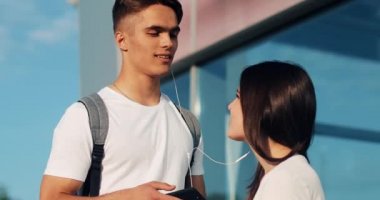 Mutlu çift aşık smartphone, kullanarak müzik dinlemek ve birbirinizle konuşun. Genç evli çift için bir uçuş havaalanında bekleyen eğleniyor