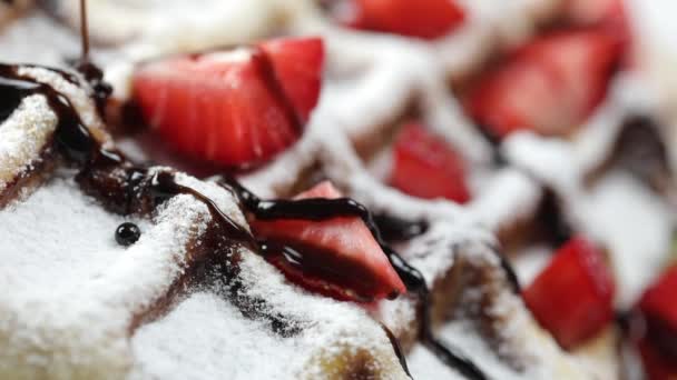 Porção de waffles belgas com morangos frescos no prato. Chocolate quente derretido derramando para waffle — Vídeo de Stock