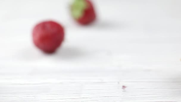 La fresa fresca, que se vierte de una taza de gofres sobre un fondo de madera clara. Baya, fresa, helado de frutas, taza de helado — Vídeo de stock