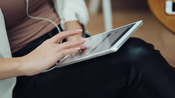 Close-up van dames vinger werken met een tablet op haar knieen — Stockvideo