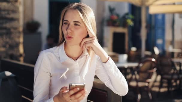 Atraktivní obchodní žena sitiing na lavičce pomocí smartphone online komunikace sociální sítě spojující při pohledu na Internetu zobrazit staré budovy na pozadí slunečný den — Stock video