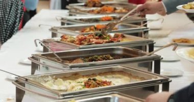 İnsanlar yemeklerini açık büfe yemek kapalı lüks restoranda et renkli meyve ve sebzeler ile grup. Yakın çekim. Ziyafet, yemek, kötü beslenme, oburluk kavramı