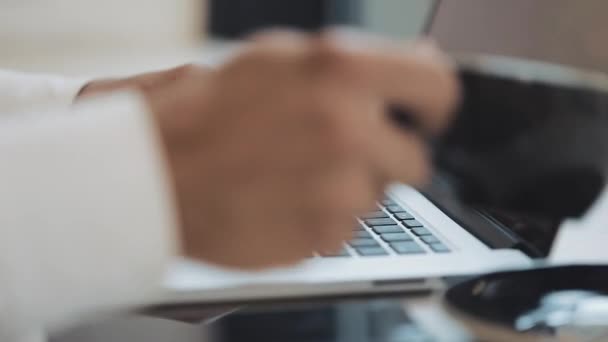 Genç adam bir kahve molası kahve içiyor ve bir dizüstü bilgisayar kullanarak, el yakın çekim — Stok video