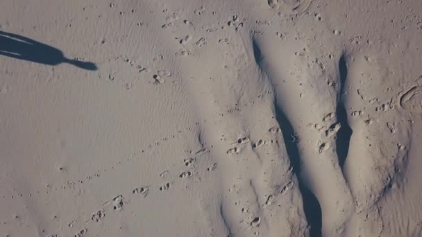 Luftaufnahmen. Drei Männer treffen sich in der Wüste. wirft die Sonne Schatten in den Sand. Ansicht von oben — Stockvideo