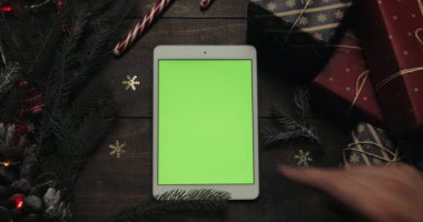 Erkek yeşil ekran beyaz tablet bilgisayarınızla sayfalarında dokunarak eller. Chroma anahtar. Üstten görünüm. Dikey konum. Yılbaşı yeni yıl kavramı