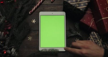 Kaydırma, dokunarak, yeşil ekran ile beyaz tablet bilgisayarda sayfa yakınlaştırma erkek eller. Chroma anahtar. Üstten görünüm. Dikey konum. Yılbaşı yeni yıl kavramı.