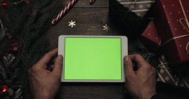 Beyaz holding erkek eller tablet bilgisayara yeşil ekran ile. Chroma anahtar. Üstten görünüm. Dikey konum. Yılbaşı yeni yıl kavramı
