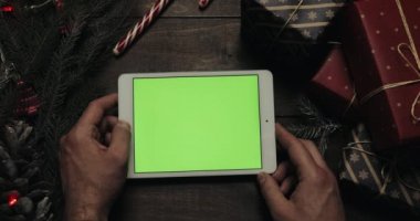 Beyaz holding erkek eller tablet bilgisayara yeşil ekran ile. Chroma anahtar. Üstten görünüm. Dikey konum. Yılbaşı yeni yıl kavramı