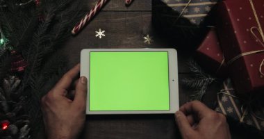 Beyaz holding erkek eller tablet bilgisayara yeşil ekran ile. Chroma anahtar. Üstten görünüm. Dikey konum. Yılbaşı yeni yıl kavramı