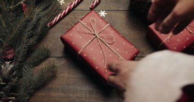 Noel baba yerine el ile yeni yıl dekorasyon tarzı ahşap arka plan ve Xmas ağacı bulanık yanıp sönen ışıkları ile büyük yeni yıl hediyesi vermek