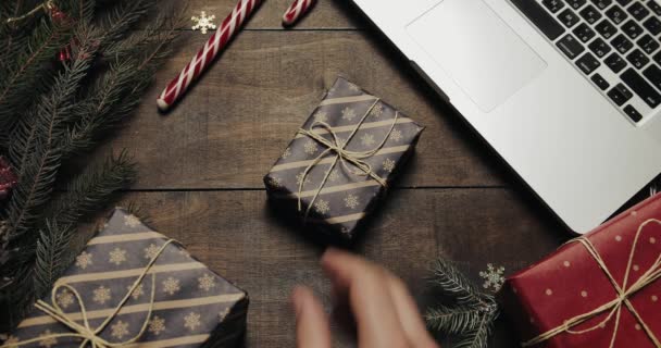 Felülnézet. Holiday Karácsonyfája gyönyörű fából készült asztal. Férfi kezében egy ajándék hozza az asztalra. Karácsonyi ünnep dekoráció felülnézet koncepció. Fából készült háttér — Stock videók