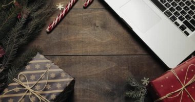 Üstten görünüm. Güzel ahşap masa Noel tatil dekorasyonu ile. Noel Baba'nın ellerini bir hediye masaya koyar. Noel tatil dekorasyon üstten görünüm kavramı. Ahşap arka plan