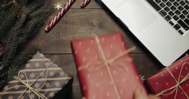 Üstten görünüm. Güzel ahşap masa Noel tatil dekorasyonu ile. Erkek ellerini bir hediye masaya koyar. Noel tatil dekorasyon üstten görünüm kavramı. Ahşap arka plan