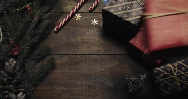 Top view. Beautiful wooden table with christmas holiday decoration. Male hands puts a gift on the table. Christmas holiday decoration top view concept. Wooden background — Stock Video