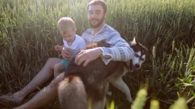 Baba ve oğul buğday sahada bir köpekle oynamayı. Babalar günü Aile kavramı