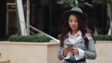 Profesyonel genç iş kadını Smartphone kullanarak kentsel sokakta yürümek. Konsept: yeni iş, iletişim, bankacı. Dış, ağır çekim