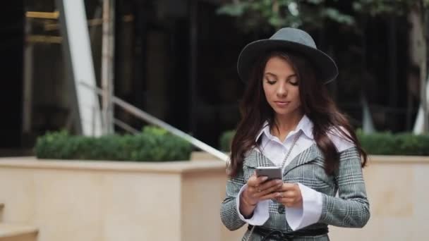 Jeune femme d'affaires professionnelle marchant dans la rue urbaine en utilisant un smartphone. Concept : nouvelle entreprise, communication, banquier. Dehors, au ralenti — Video