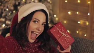 Noel ağacı yakınındaki evde hediye ile smartphone makinesinde selfie fotoğraf çekmek güzel güleryüzlü kadın