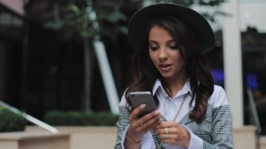 Mutlu genç iş kadını Smartphone kullanarak kentsel sokakta yürümek. Konsept: yeni iş, iletişim, bankacı. Dış, ağır çekim