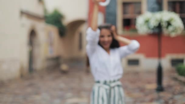 Joyeux jeune femme dansant et s'amusant avec parapluie dans la rue de la vieille ville. Belle firl regardant et posant dans la caméra, petite pluie tombant — Video