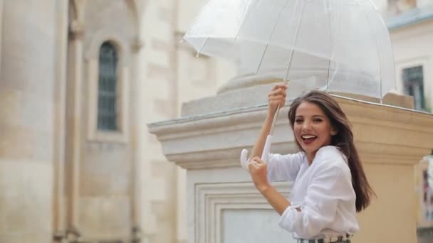 Belle jeune femme dansant et s'amusant avec parapluie dans la rue de la vieille ville après la pluie — Video