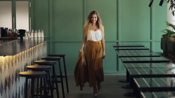 Belle jeune femme marchant près d'un bar dans un pub confortable. Elle regarde la caméra et sourit. Mode, le fondateur, dame d'affaires, concept d'entreprise de succès — Video