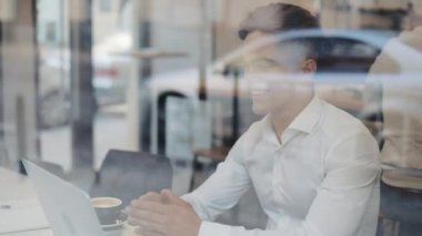 Kafede dizüstü bilgisayar ile çalışan genç mutlu bir iş adamı. İyi haber okuma. Başarılı insanlar, günlük rutin. Eğlenceli, dinlendirici, iletişim
