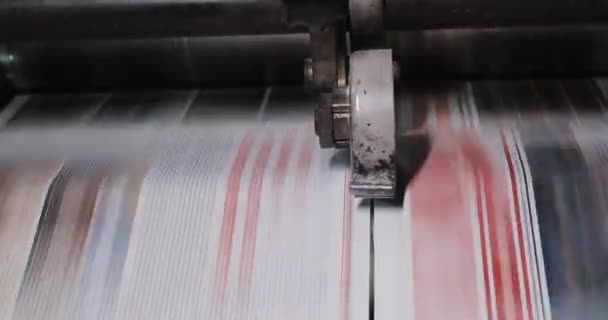 Druckereifabrik. Zeitungsdruck in einem Werk. Zeitung, die auf einer Druckereimaschine gedruckt wurde. Nahaufnahme — Stockvideo