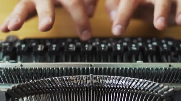 Manos de hombre escribiendo una vieja máquina de escribir. El foco no está en las manos — Vídeos de Stock