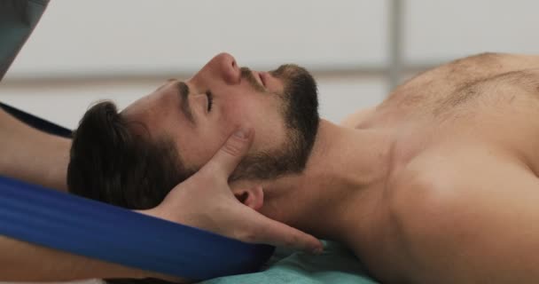Фізіотерапевт, який працює з пацієнтом у клініці. Реабілітація, професійний масаж шиї, шийний хребет — стокове відео