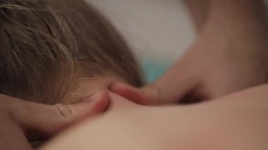 Küçük kızlar kafa bir kırıkçı tarafından manipüle ediliyordu kapatın. Alternatif Tıp tedavisi. Profesyonel bir masöz spa merkezinde bir kız için boyun masajı yapar