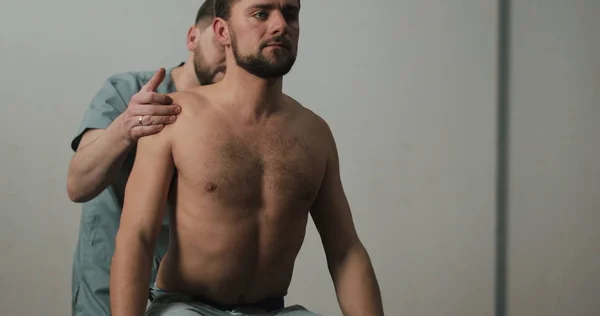 Alternative medicine treatment and rehabilitation of patients. Patient with sick spine on examination at rehab. The man receives a physiotherapy massage during a session with a chiropractor