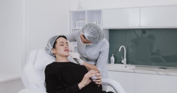 Augmentation des lèvres. Le médecin cosmétologue effectue la procédure d'augmentation des lèvres d'une belle femme dans un salon de beauté. Concept d'injection cosmétique beauté — Video