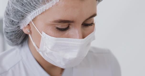 Gros plan du visage de la femme médecin dans le masque qui effectue les procédures d'injection. Portrait de docteur — Video