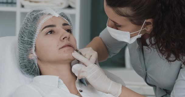 Aumento dos lábios. O médico cosmetologist faz procedimento de aumento labial de uma mulher bonita em um salão de beleza. Conceito de injeção de beleza cosmética — Vídeo de Stock