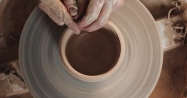 Potter, bükülmüş çömlek tekerleğinde seramik pot yapıyor. Üst görünüm. Potter iş yerinde, yakın yukarı. El yapımı, zanaat. Beyaz kil