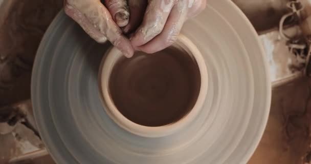 Potter, bükülmüş çömlek tekerleğinde seramik pot yapıyor. Üst görünüm. Potter iş yerinde, yakın yukarı. El yapımı, zanaat. Beyaz kil — Stok video